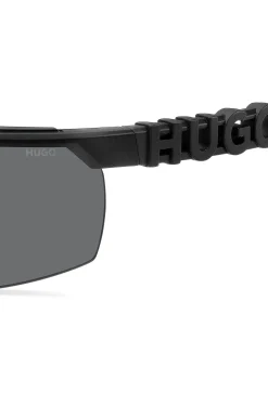 Schwarze Sonnenbrille im Masken-Stil mit 3D-Logo auf den Bügeln