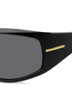 Schwarze Sonnenbrille im Masken-Stil mit goldfarbenen Metalldetails